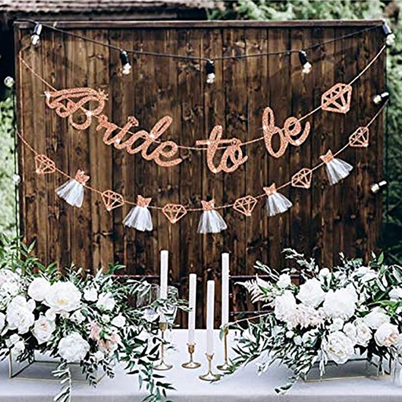 Decorative banner with 'Bride to be' on a wooden backdrop with flowers and candles.